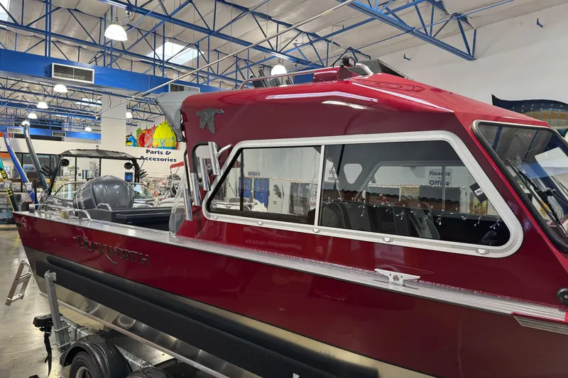 Slide: The Image of 2026 Duckworth 23 Pacific Navigator boat in showroom, red exterior, indoor display. - 5
