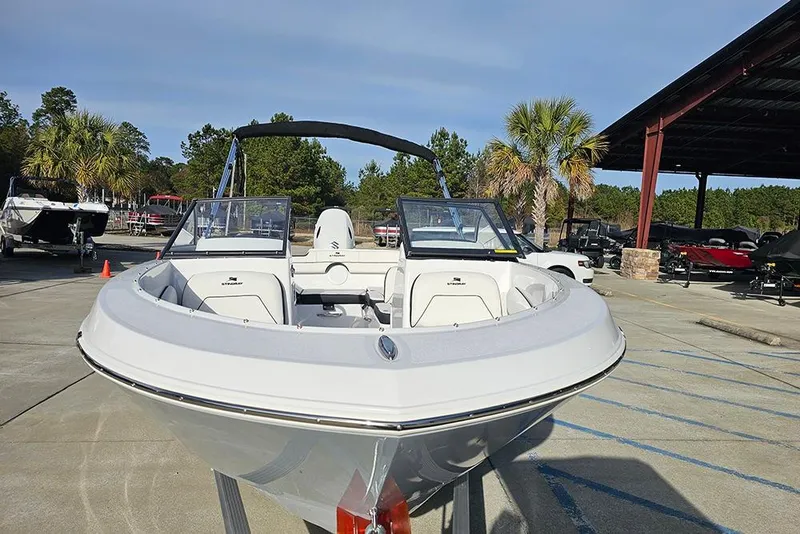 Slide: The Image of 2026 Stingray 172 DC boat displayed outdoors, surrounded by trees and other boats. - 4