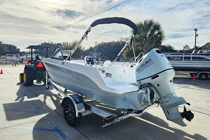 Slide: The Image of 2026 Stingray 172 DC boat with Suzuki outboard motor on trailer, sunny day. - 7