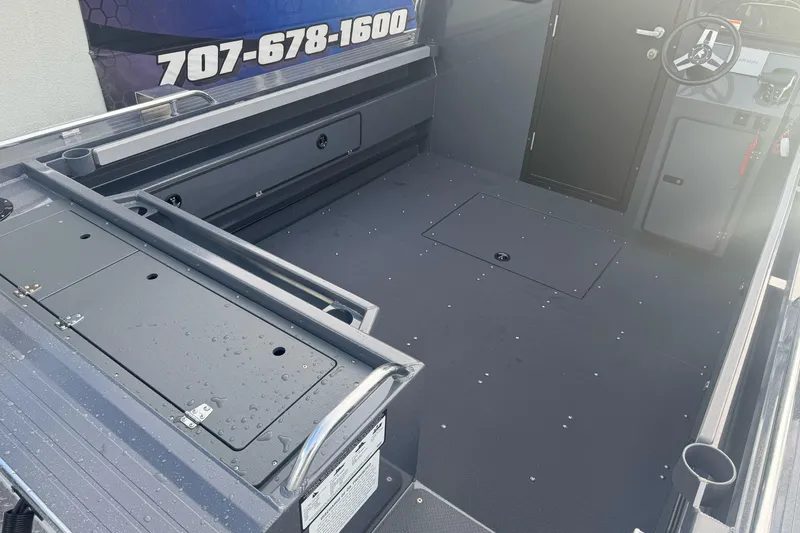 Slide: The Image of Interior view of 2026 Duckworth 24 Pacific Pro boat, showcasing spacious deck and steering area. - 10
