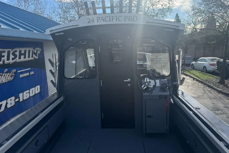 Slide: The Image of 2026 Duckworth 24 Pacific Pro boat, docked with steering console and cabin view. - 11