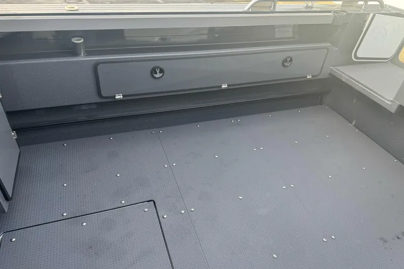 Slide: The Image of Interior of 2026 Duckworth 24 Pacific Pro boat, featuring spacious deck and storage compartments. - 15