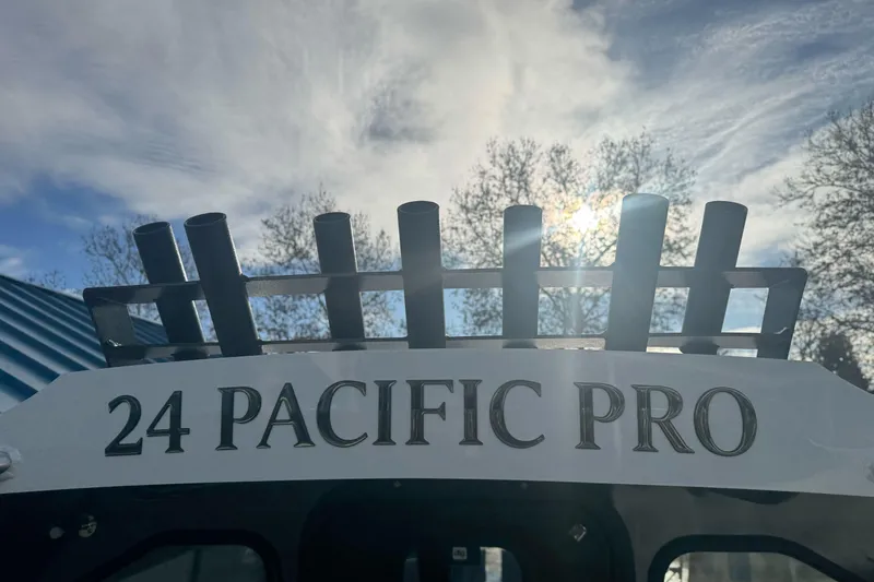 Slide: The Image of Duckworth 24 Pacific Pro 2026 boat with rod holders against a bright sky. - 21