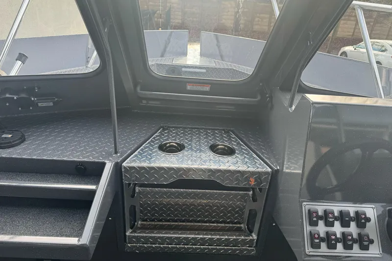 Slide: The Image of Interior of 2026 Duckworth 24 Pacific Pro boat with diamond plate flooring and control panel. - 28