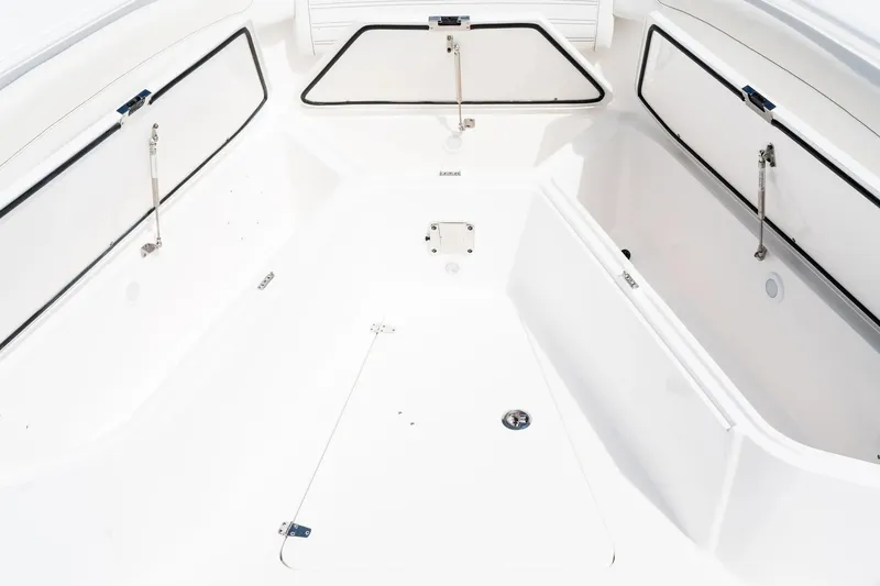 Slide: The Image of 2026 Edgewater 340CC boat interior with open storage compartments, showcasing sleek white design. - 24