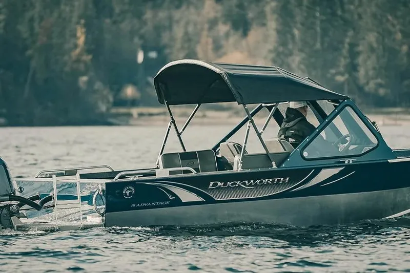The Image of 2026 Duckworth 18 Advantage boat cruising on a serene lake with canopy. - 1