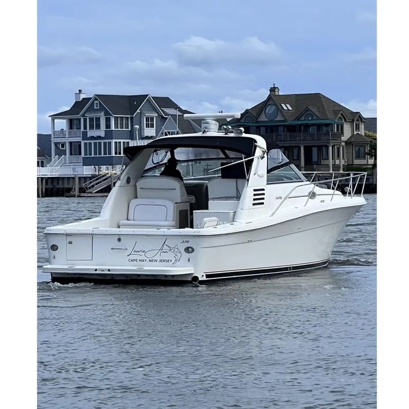 The Image of 1998 Sea Ray 340 Amberjack boat on water near coastal homes. - 0