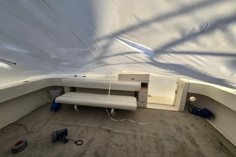 Slide: The Image of 1998 Sea Ray 340 Amberjack interior with seating, carpet, and equipment under a protective cover. - 37