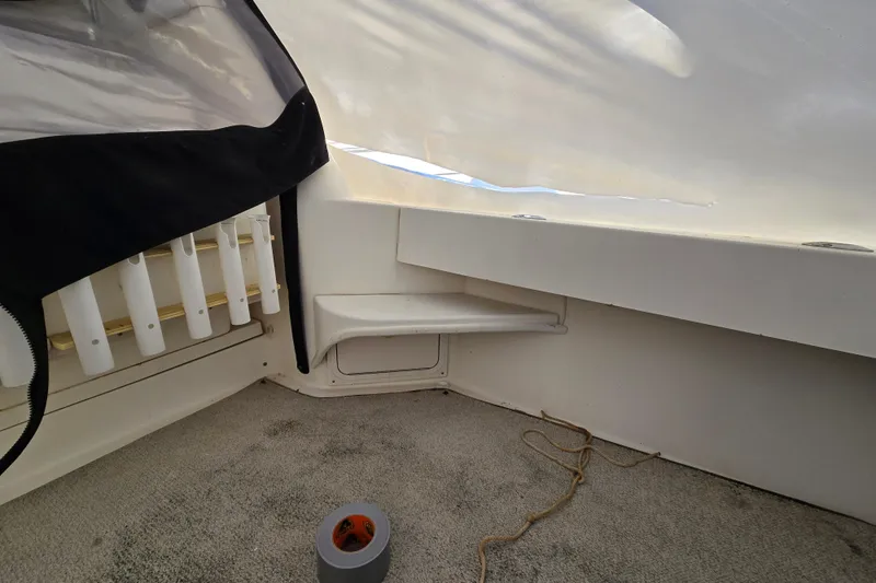 Slide: The Image of Interior view of a 1998 Sea Ray 340 Amberjack boat with rod holders and carpeted floor. - 38