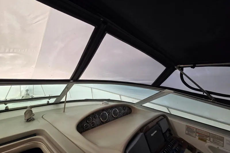 Slide: The Image of 1998 Sea Ray 340 Amberjack helm with gauges and navigation equipment under a covered canopy. - 45