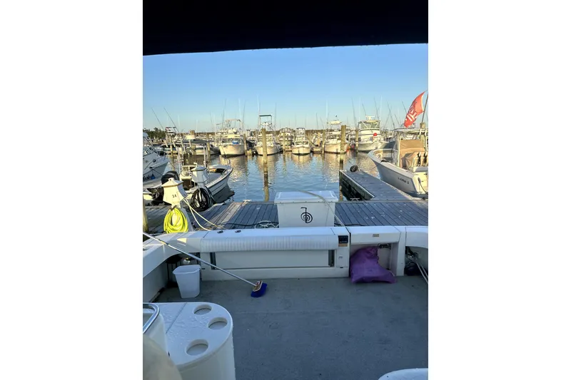 Slide: The Image of 1998 Sea Ray 340 Amberjack at marina, surrounded by boats and clear blue sky. - 5