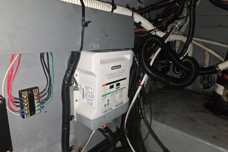 Slide: The Image of Electrical system inside a 1998 Sea Ray 340 Amberjack boat, featuring wiring and a ProNautic charger. - 55