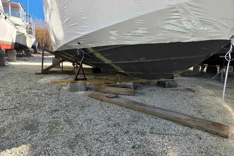 Slide: The Image of 1998 Sea Ray 340 Amberjack boat stored on blocks, covered for protection. - 58