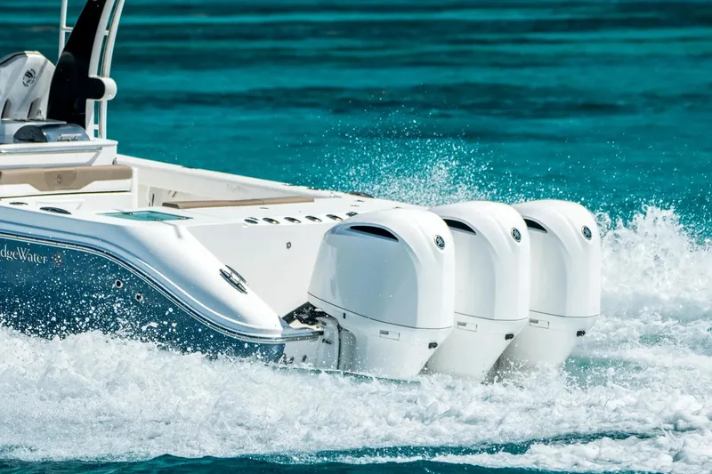 Slide: The Image of 2026 Edgewater 370CC boat with triple outboard engines cruising on clear blue water. - 3