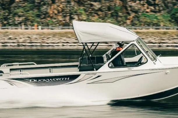 Slide: The Image of 2026 Duckworth 20 Advantage Classic boat speeding on water with canopy. - 2