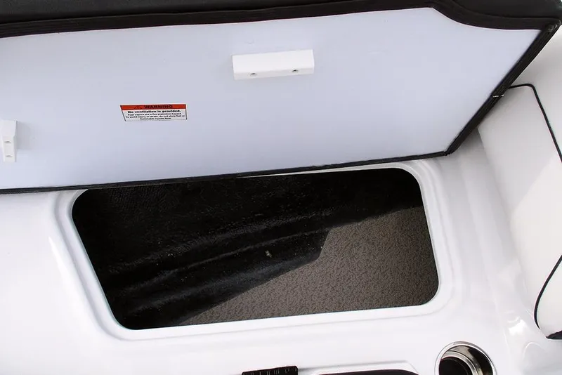 Slide: The Image of Storage compartment of 2026 Stingray 182 SC boat, featuring a white lid and warning label. - 14