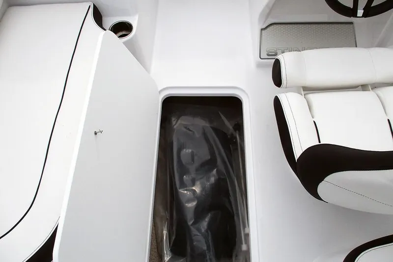 Slide: The Image of 2026 Stingray 182 SC boat interior with white seating and storage compartment. - 17