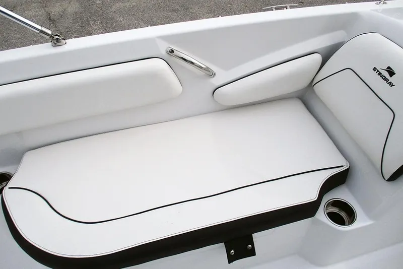 Slide: The Image of 2026 Stingray 182 SC boat interior with white cushioned seating and cup holder. - 18