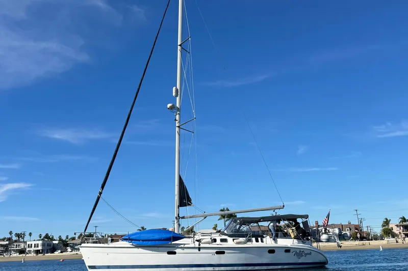 The Image of 2000 Hunter 460 sailboat on calm water, clear sky, coastal background. - 0