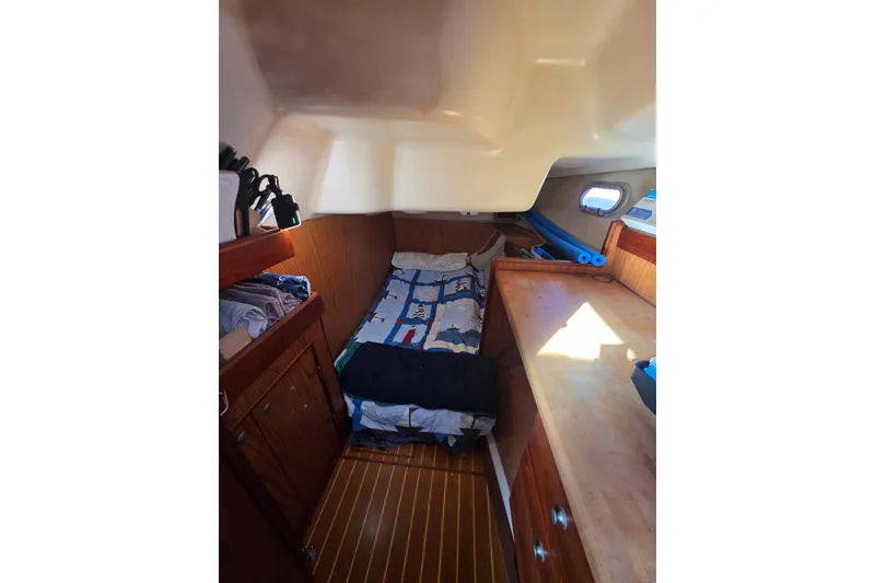 Slide: The Image of Interior of 2000 Hunter 460 sailboat with kitchen, bed, and wooden finishes. - 11