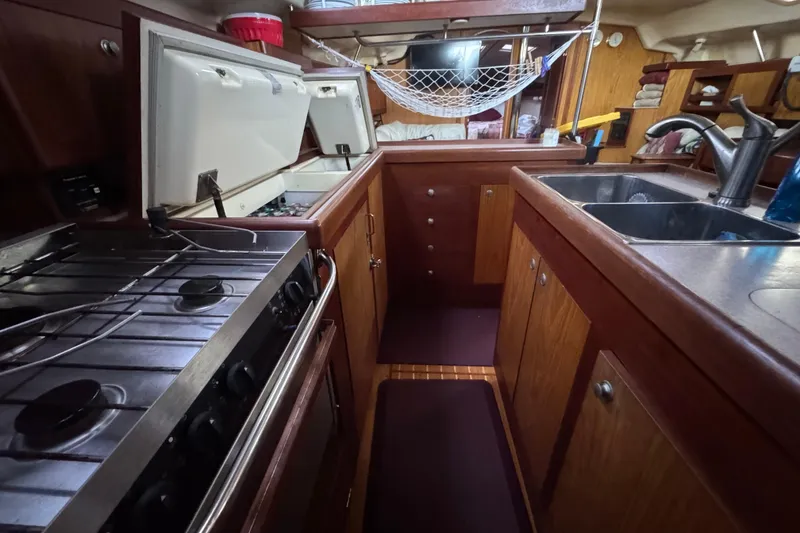 Slide: The Image of Interior of a 2000 Hunter 460 sailboat, featuring wood paneling and compact living space. - 14