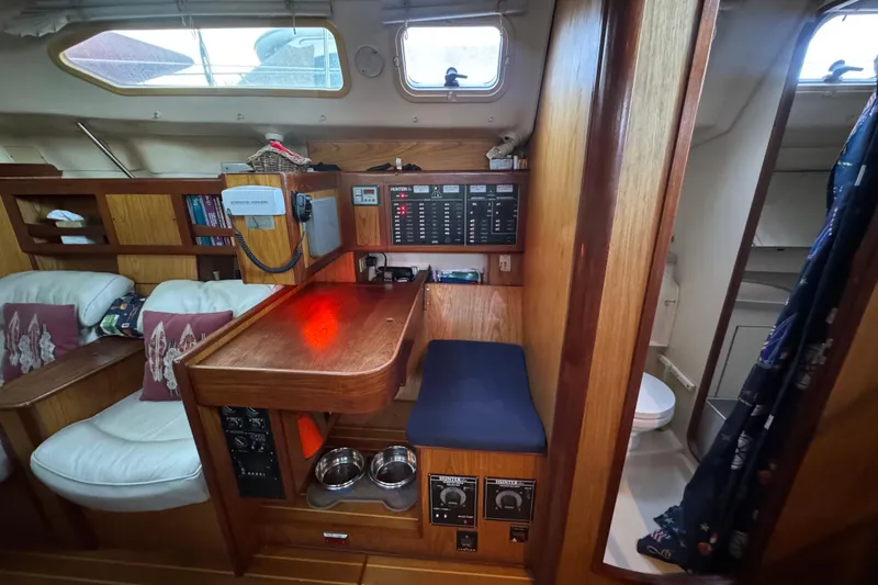Slide: The Image of Interior of a 2000 Hunter 460 sailboat with wood paneling and seating area. - 16