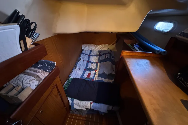Slide: The Image of Cozy cabin interior of 2000 Hunter 460 yacht with bed and wooden storage. - 19