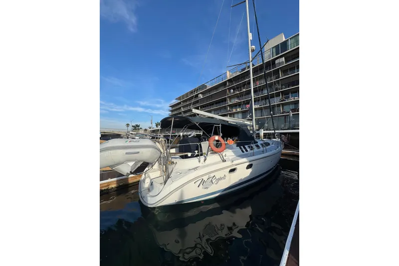 Slide: The Image of Hunter 460 yacht from 2000 docked with inflatable boat and American flag. - 2