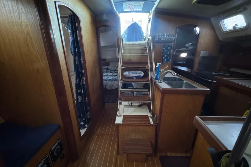 Slide: The Image of Cozy cabin interior of 2000 Hunter 460 sailboat with colorful quilt and fishing rods. - 20