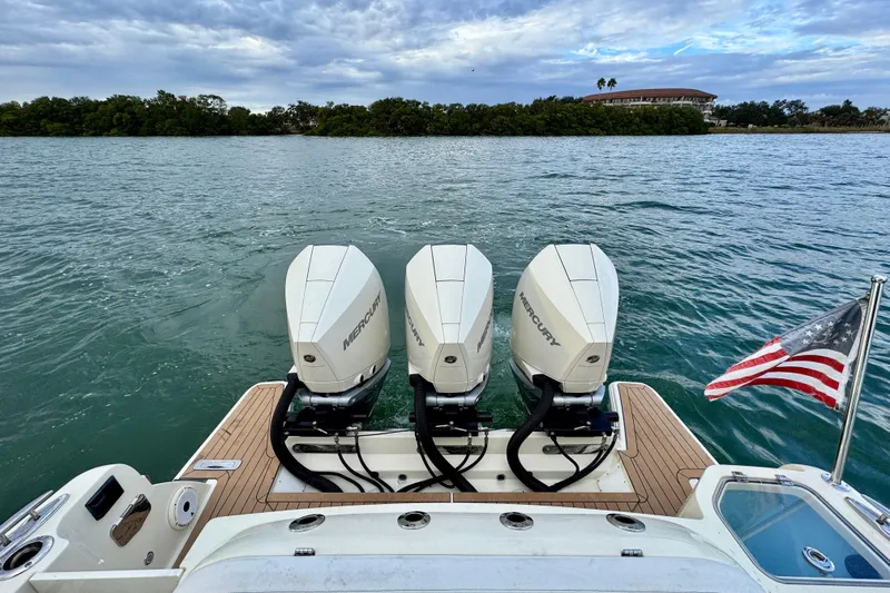 Slide: The Image of 2021 Chris-Craft Calypso 35 with triple Mercury engines and American flag on water. - 10