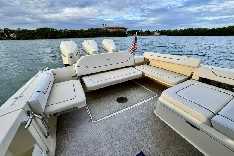 Slide: The Image of 2021 Chris-Craft Calypso 35 boat interior with seating and Mercury engines on a scenic waterway. - 14