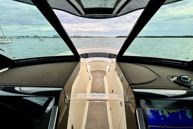 Slide: The Image of 2021 Chris-Craft Calypso 35 interior view with ocean backdrop and navigation display. - 33