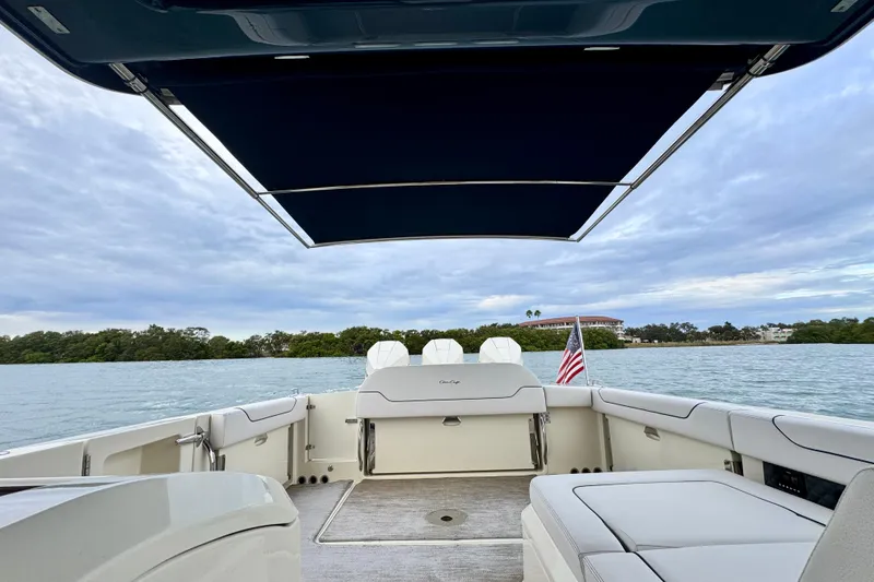 Slide: The Image of 2021 Chris-Craft Calypso 35 boat interior with canopy, overlooking serene water and shoreline. - 43