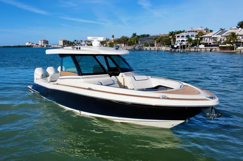 Slide: The Image of 2021 Chris-Craft Calypso 35 boat on calm water, with luxury waterfront homes in the background. - 7