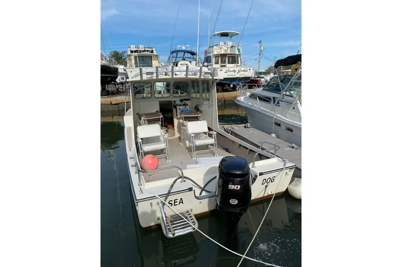 Slide: The Image of 2007 Retro Cape Island Trawler docked, featuring an outboard motor and open deck seating. - 4
