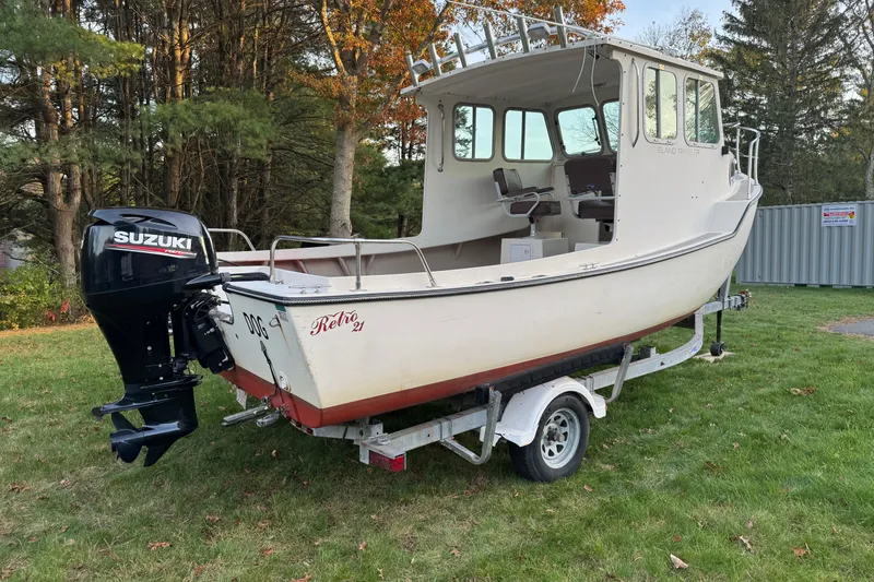 Slide: The Image of 2007 Cape Island Pilot boat on trailer with Suzuki outboard motor, parked on grass. - 5