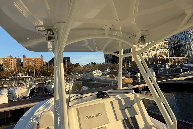 Slide: The Image of 2019 Regulator 23 boat docked at marina with Garmin equipment, cityscape background. - 10