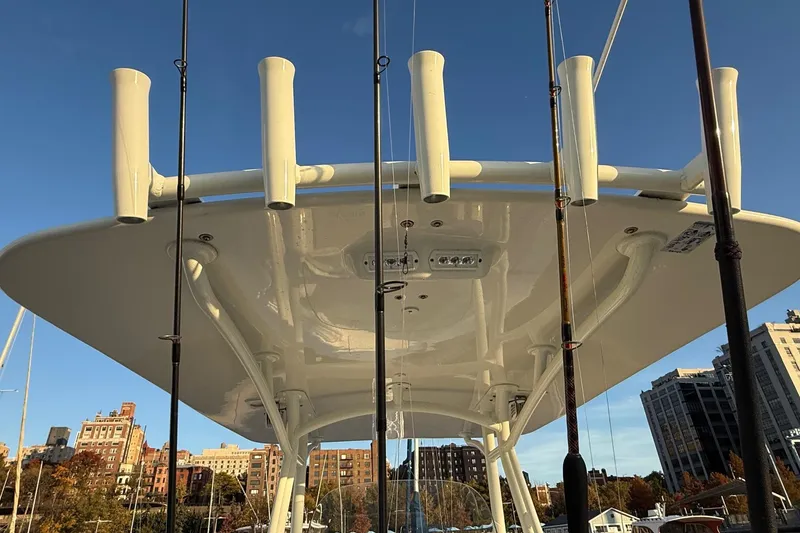 Slide: The Image of 2019 Regulator 23 boat with rod holders and cityscape background. - 12