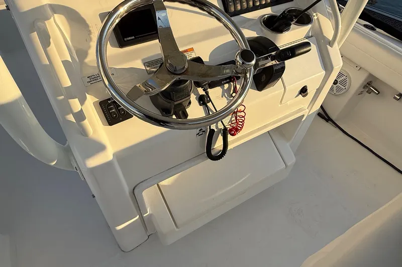Slide: The Image of 2019 Regulator 23 boat helm with steering wheel and controls. - 14