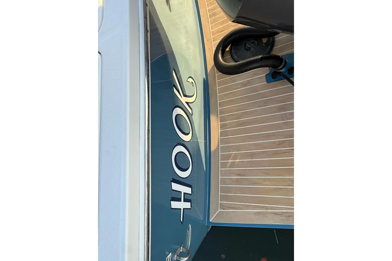 Slide: The Image of 2019 Regulator 23 boat deck with "Hook" lettering, featuring wood-style flooring. - 16