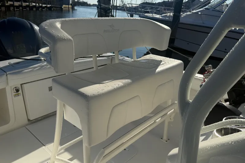 Slide: The Image of 2019 Regulator 23 boat seat with morning dew, docked near other vessels. - 22