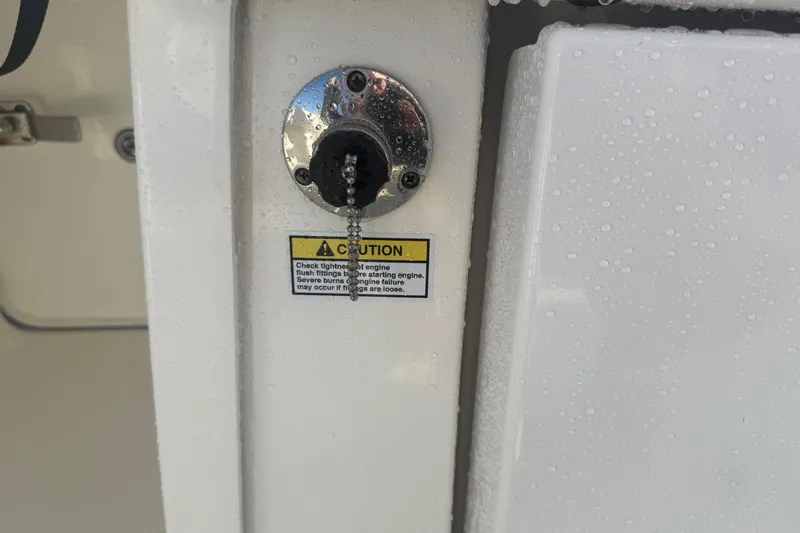 Slide: The Image of 2019 Regulator 23 boat engine flush fitting with caution label. - 24