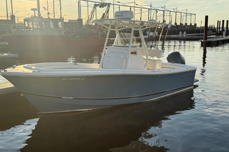 Slide: The Image of 2019 Regulator 23 boat docked at marina during sunset. - 3