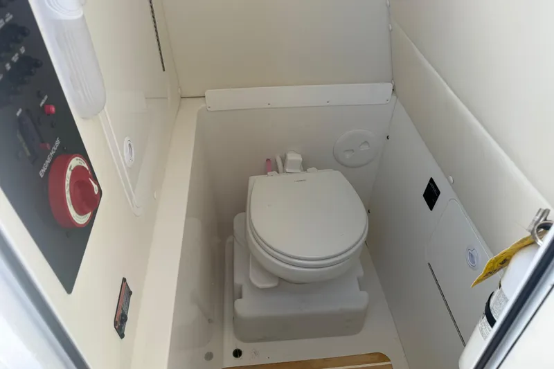 Slide: The Image of 2019 Regulator 23 boat interior with compact marine toilet and control panel. - 31