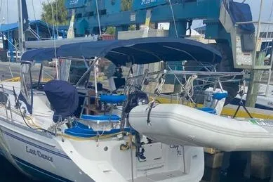 Slide: The Image of 2011 Catalina 355 sailboat docked with blue canopy and attached dinghy. - 21