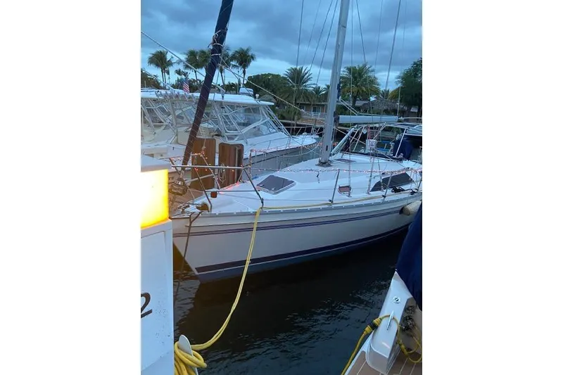 Slide: The Image of 2011 Catalina 355 sailboat docked at marina with palm trees in background. - 25