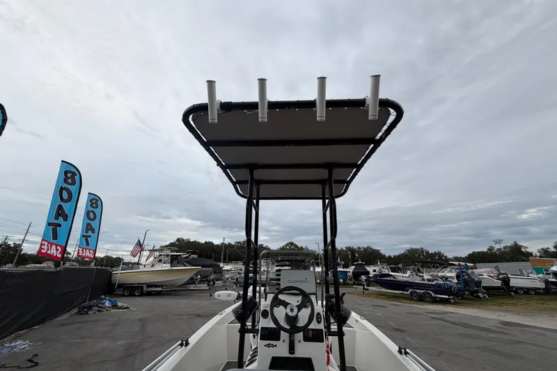 Slide: The Image of 2024 Mako Pro Skiff 15 CC boat at a sale event, featuring a T-top and Garmin equipment. - 10