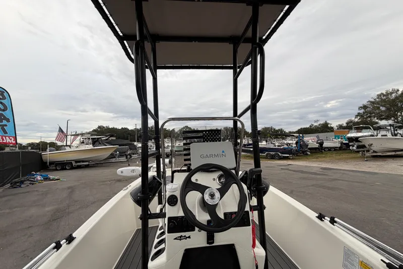 Slide: The Image of 2024 Mako Pro Skiff 15 CC boat with Garmin navigation, displayed at a boat sale event. - 13