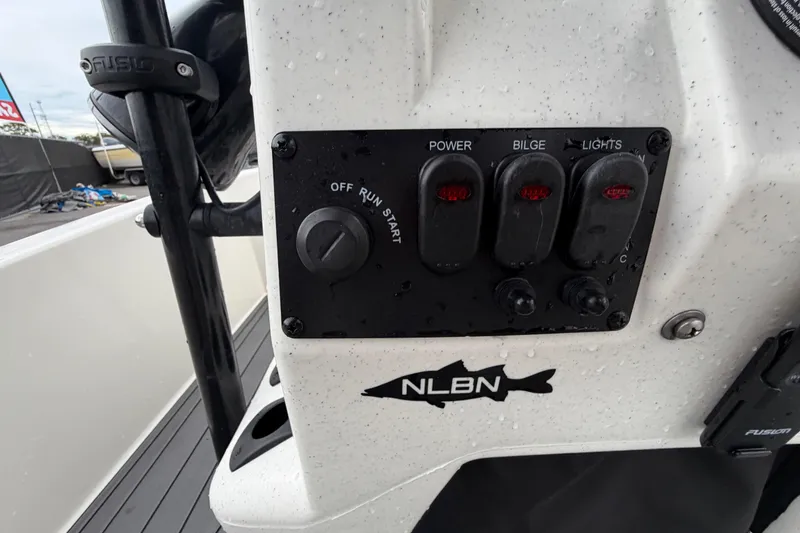 Slide: The Image of 2024 Mako Pro Skiff 15 CC control panel with power, bilge, and light switches. - 15