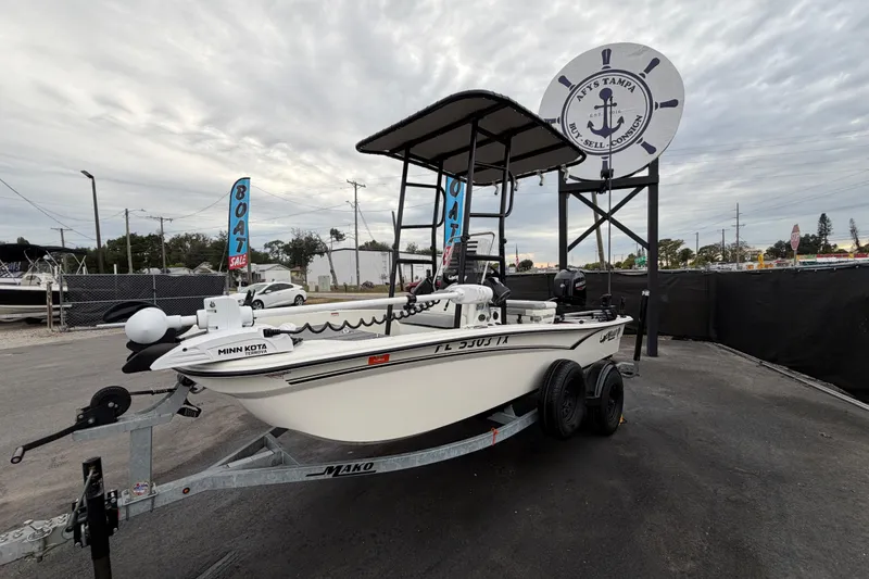 Slide: The Image of 2024 Mako Pro Skiff 15 CC boat on trailer, displayed at a boat sale event. - 7